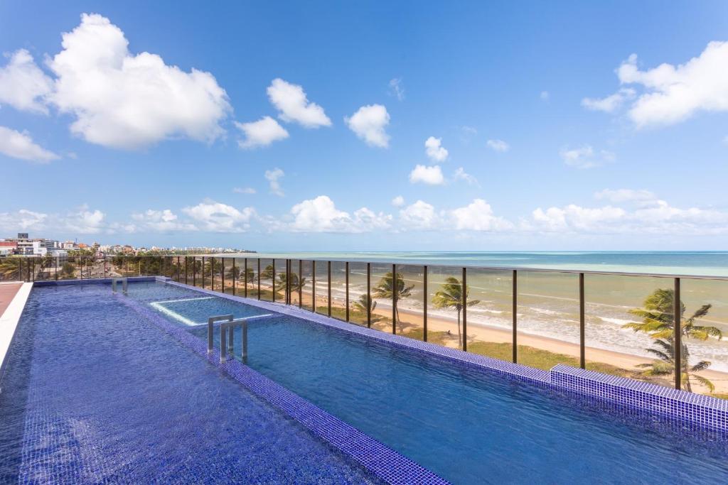 a swimming pool with a view of the beach at Apartamento NOVO - Beira mar de Intermares in Cabedelo