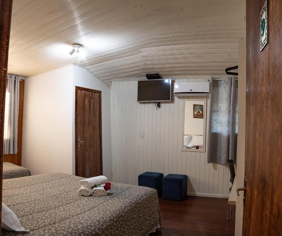um quarto de hotel com duas camas e uma televisão de ecrã plano em Pousada Don Marini em Bento Gonçalves