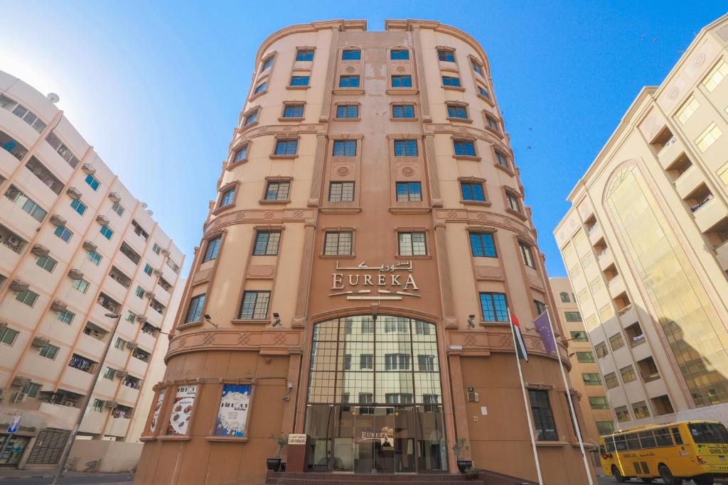 a tall brown building with a sign on it at OYO 367 Eureka Hotel in Dubai