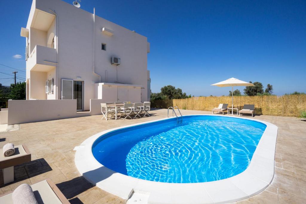 une villa avec une piscine en face d'une maison dans l'établissement Villa Cacasa, à Khoumérion