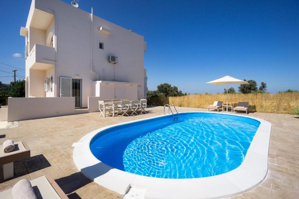 a villa with a swimming pool in front of a house at Villa Cacasa in Khoumérion