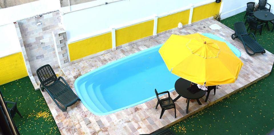 an overhead view of a pool with an umbrella and chairs at Arena Maracanã Hostel in Rio de Janeiro