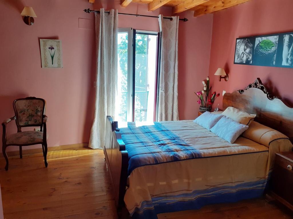 a bedroom with a bed and a window and a chair at Los Castaños in Solana de ávila