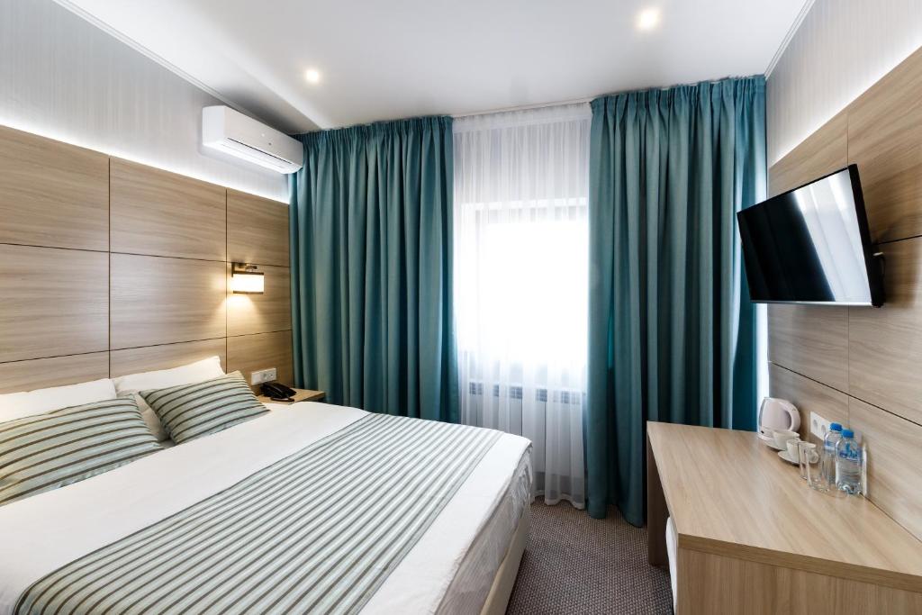 サマラにあるInter Hotelのベッドとテレビが備わるホテルルームです。