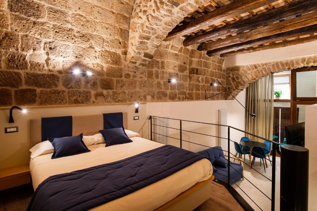 a bedroom with a large bed in a brick wall at Le Stanze di Teodorico in Orvieto