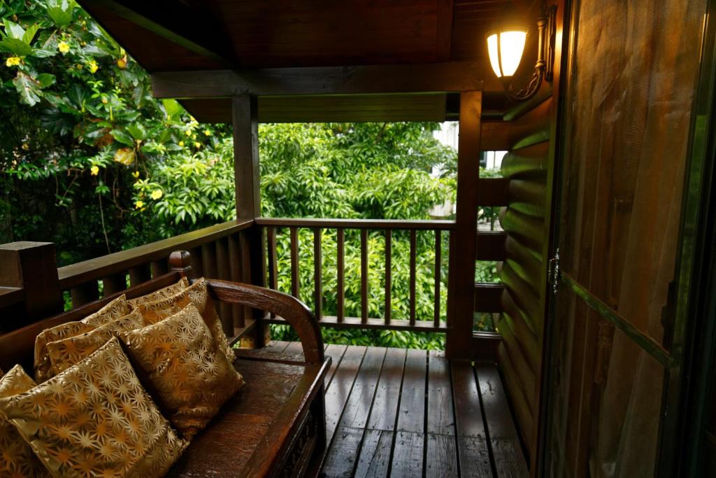 a wooden bench sitting on a wooden porch at Sun Moon Lake Full House Resort in Yuchi