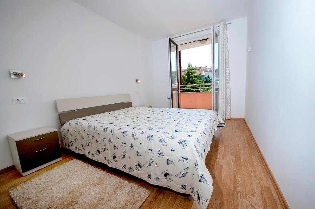 sypialnia z łóżkiem i dużym oknem w obiekcie Apartments Centener w Rovinj