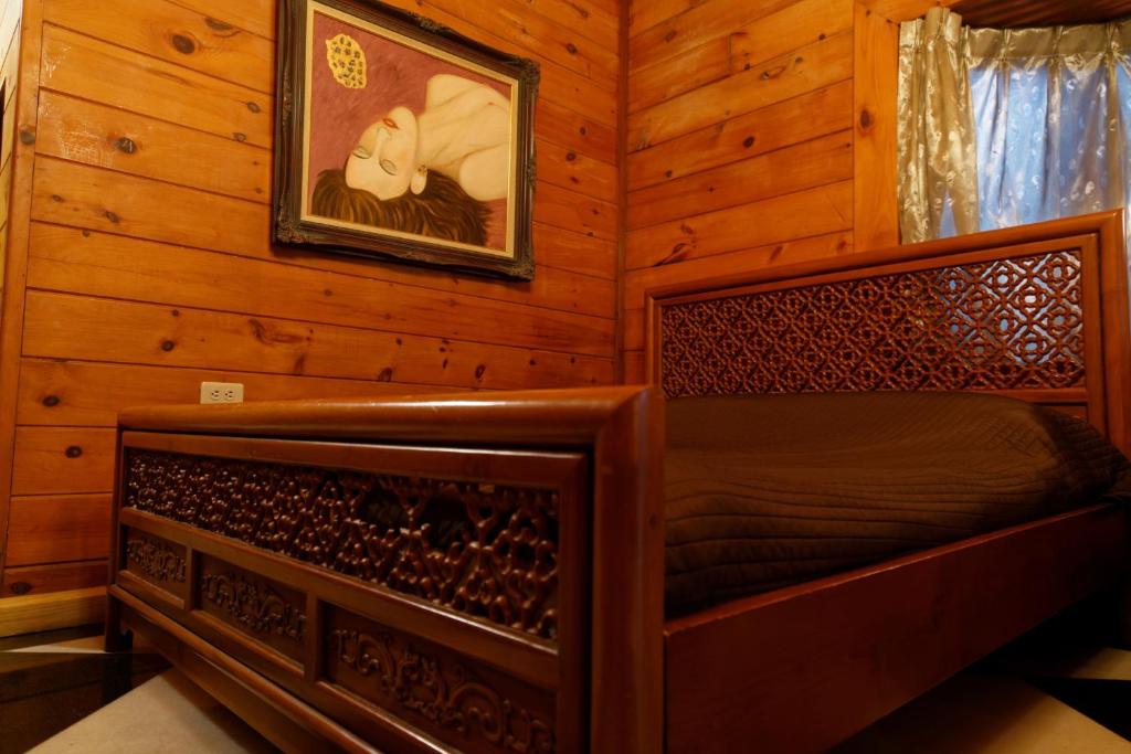 a bedroom with a bed in a log cabin at Sun Moon Lake Full House Resort in Yuchi