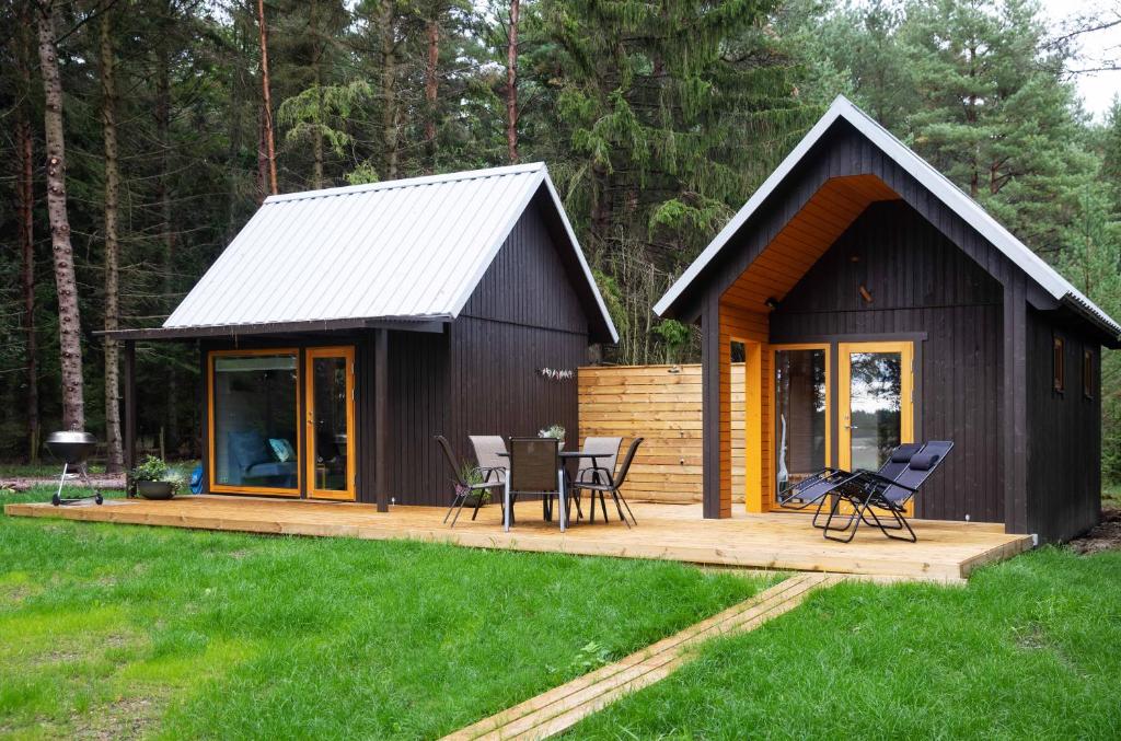 een kleine hut met een tafel en stoelen op een terras bij Valhalla puhkemaja Hiiumaal in Hiiessaare