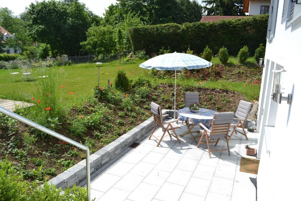 a patio with a table and chairs and an umbrella at Ferienwohnung Meding am See in Schondorf am Ammersee