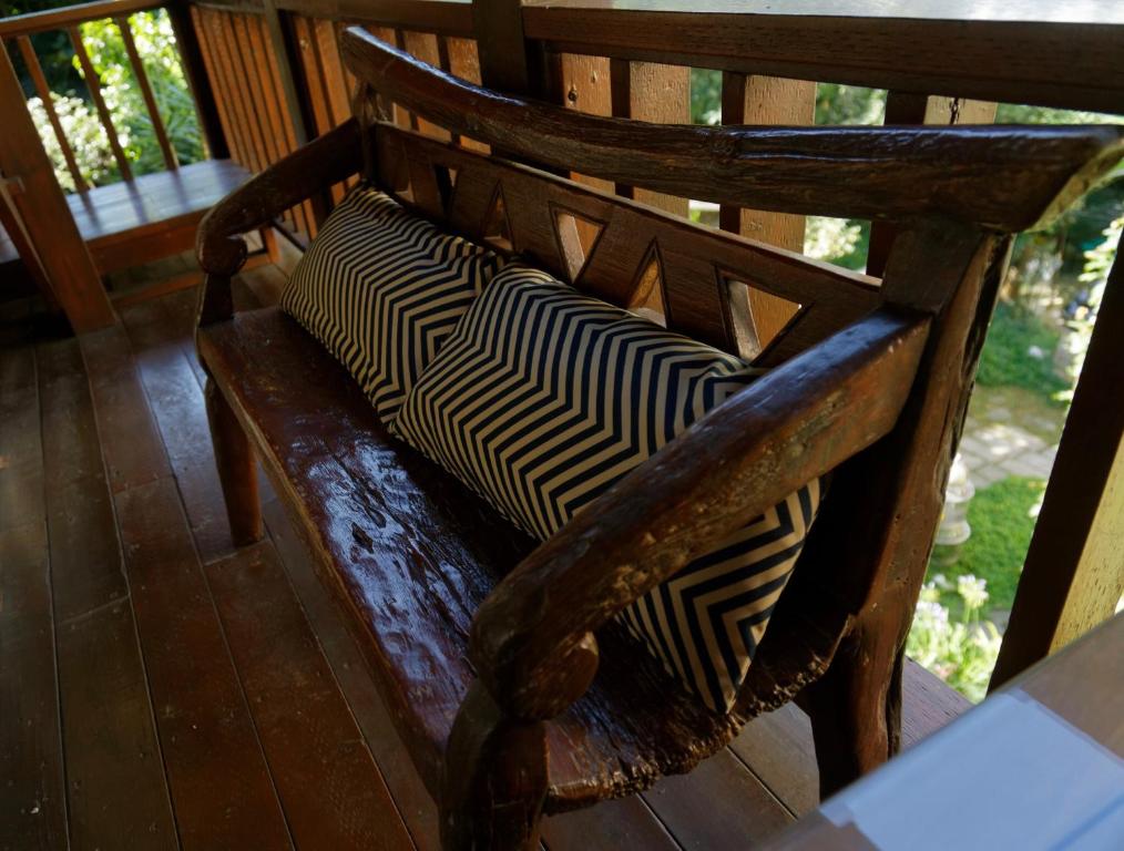 a wooden bench with two pillows on a porch at Sun Moon Lake Full House Resort in Yuchi