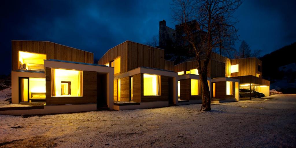 un bâtiment avec des lumières allumées dans la neige la nuit dans l'établissement Refugio Laudegg, à Ladis