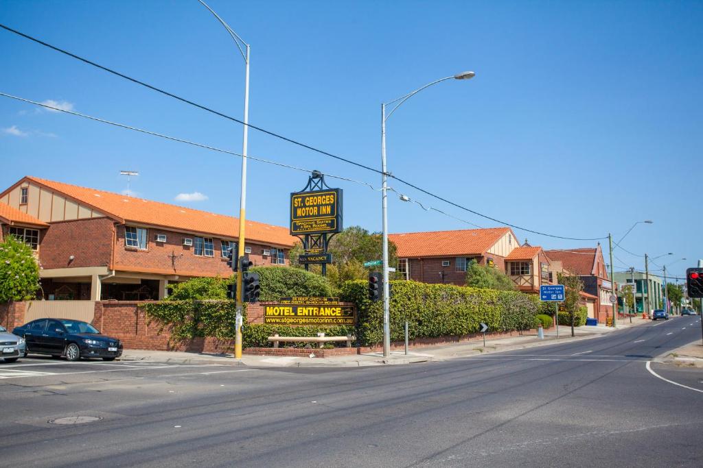 墨爾本的住宿－聖喬治汽車旅館，建筑物前有标志的空街道