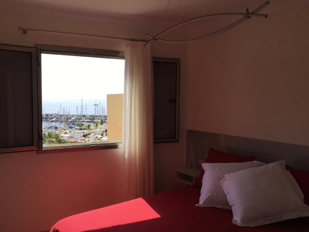a bedroom with a bed with a large window at Sunset Puerto de Mogan in Puerto de Mogán