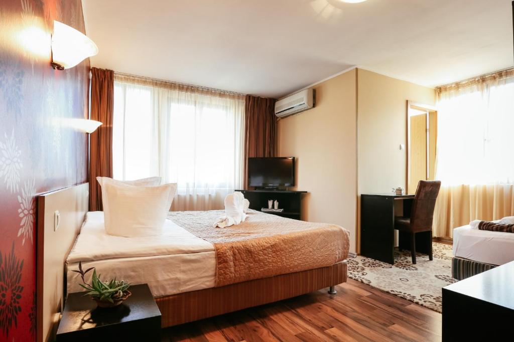 a hotel room with a bed and a television at Vila Vidalis in Cluj-Napoca