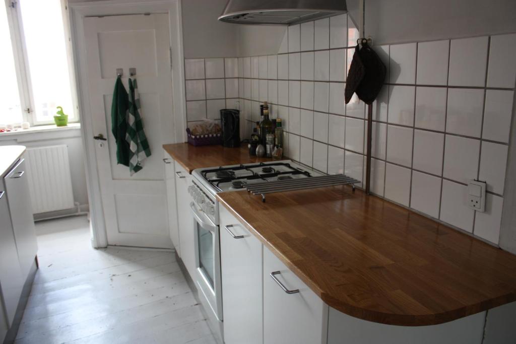 a kitchen with a stove and a wooden counter top at Nyhavn Apartment in Copenhagen