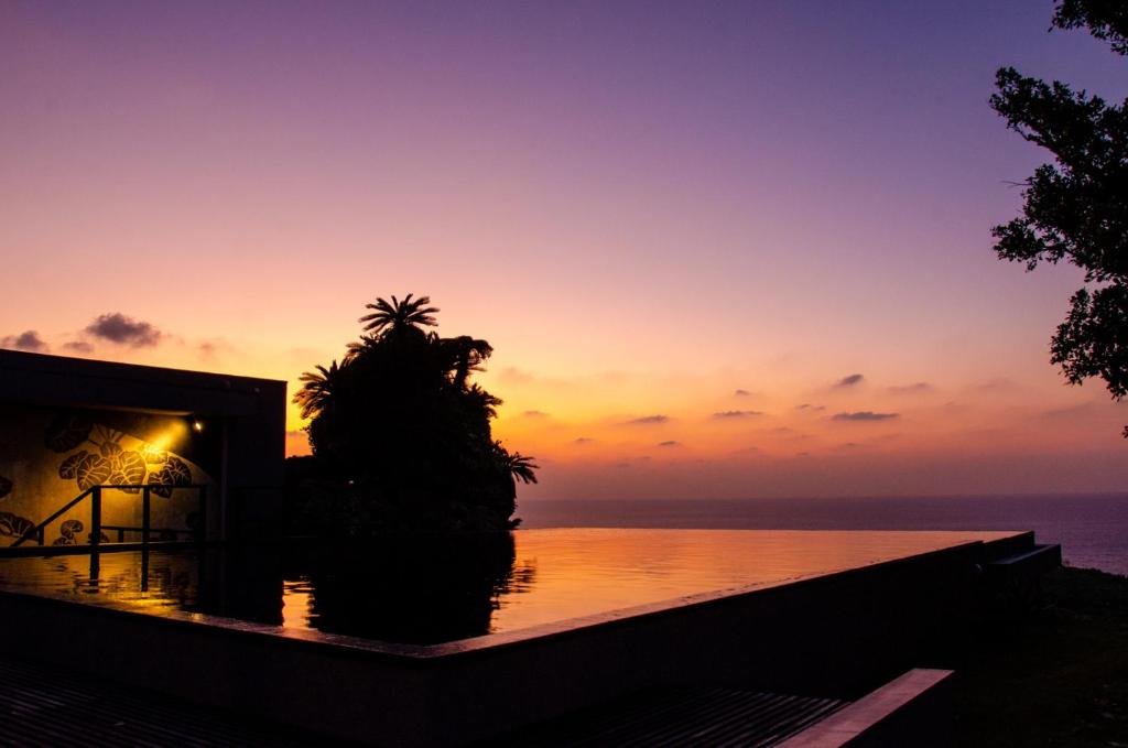 Hanalee Villa Kouri في ناكيجين: غروب الشمس على المحيط من الفيلا