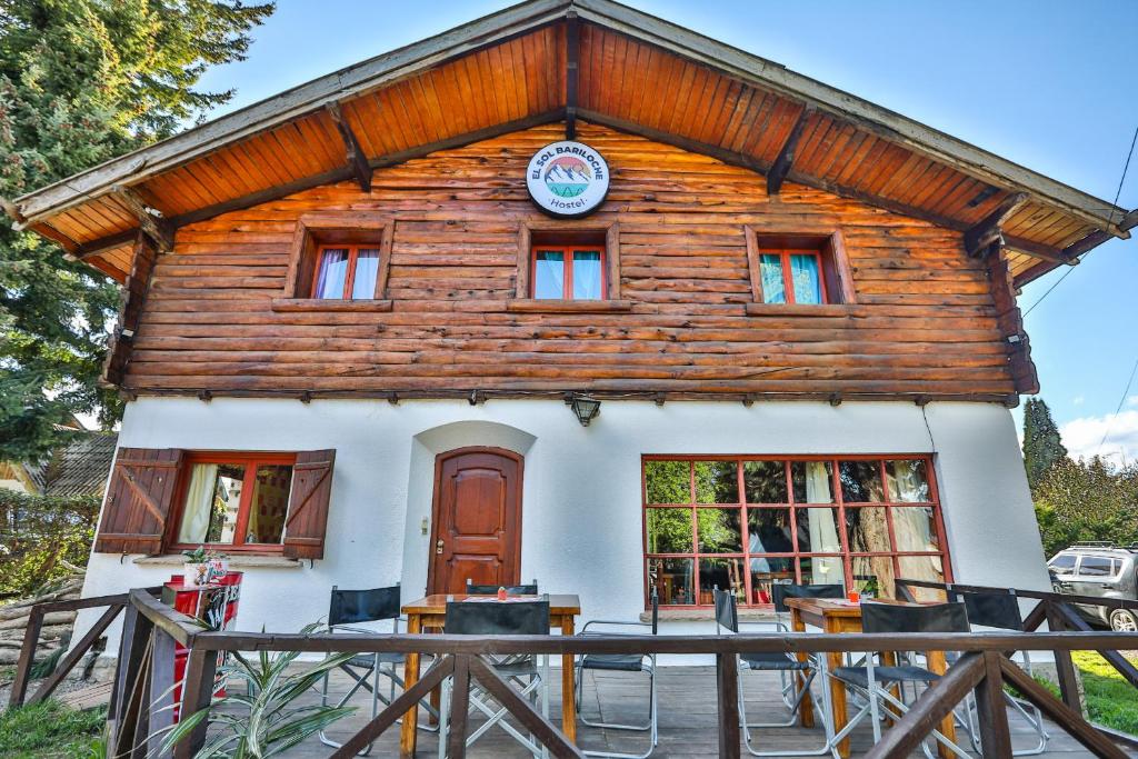 Una casa de madera con un reloj en la parte delantera. en KM SUN HOSTEL en San Carlos de Bariloche