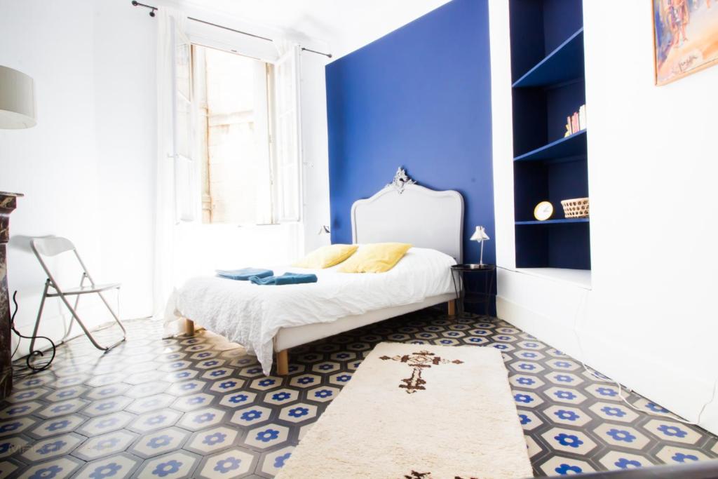 - une chambre avec des murs bleus et un lit avec un tapis dans l'établissement Le comédien - Climatisation Place de la comédie, à Montpellier