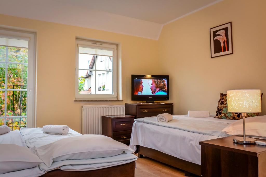 a room with two beds and a television in it at Pensjonat Stach in Ustka
