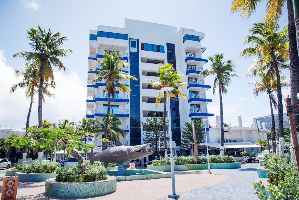ein großes Gebäude mit Palmen davor in der Unterkunft Sol Caribe Sea Flower in San Andrés
