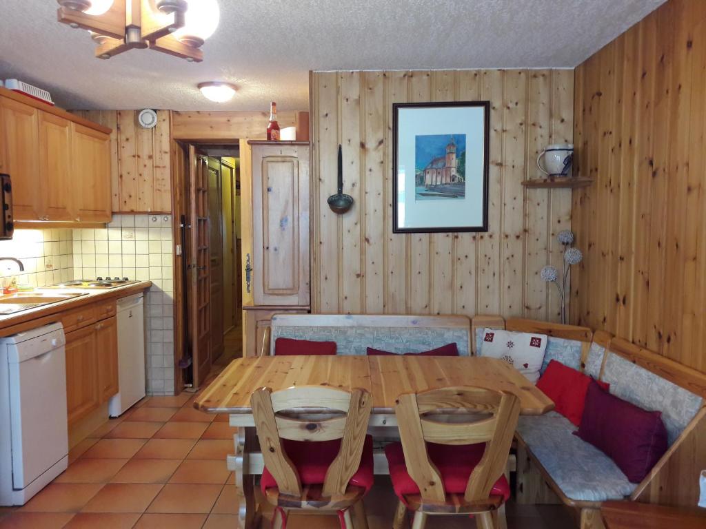 cocina con mesa de madera y sillas en una habitación en Le Panda en Les Carroz d'Araches