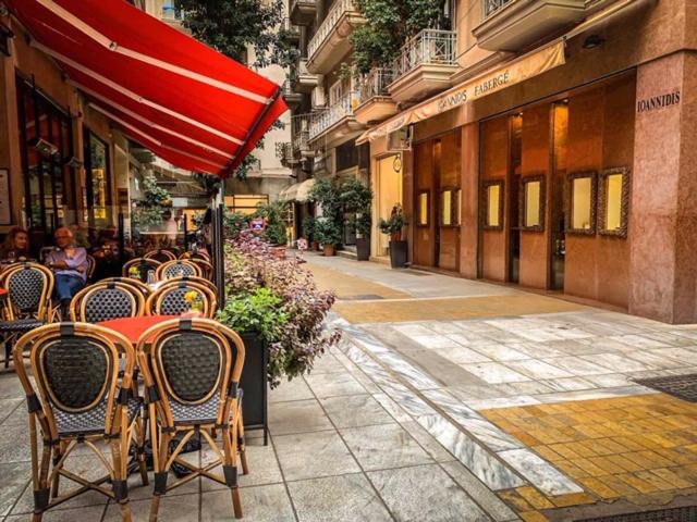 雅典的住宿－API Projects Athens - Cartier Apartment，街上一张桌子、椅子和一把遮阳伞
