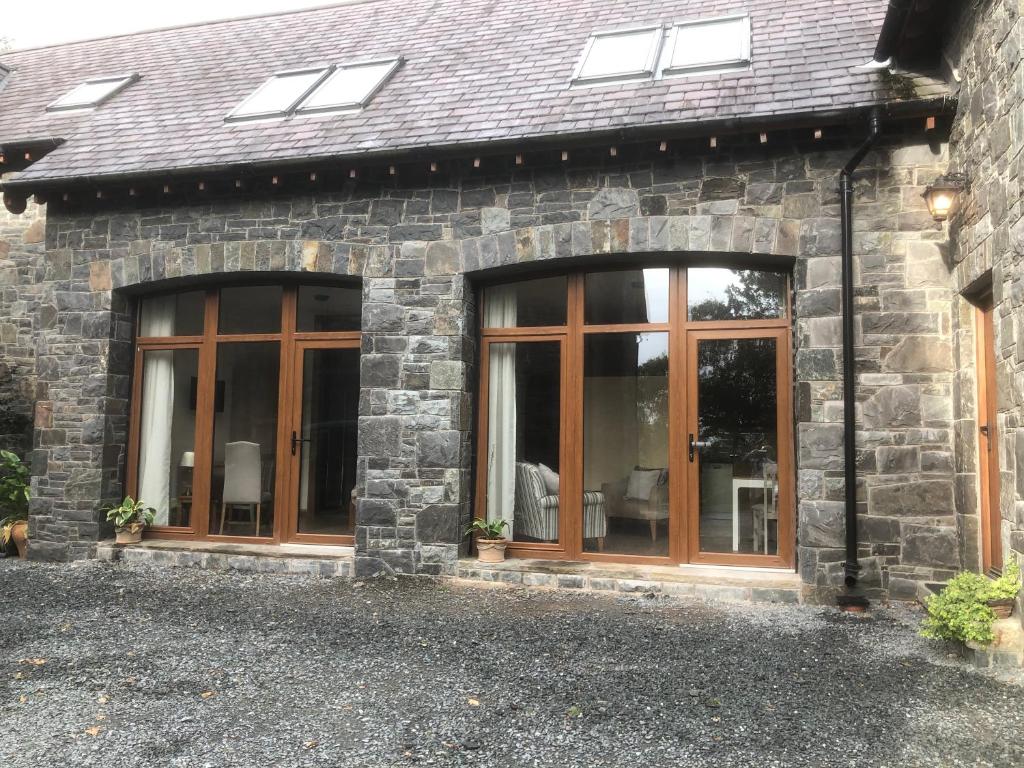 una casa de piedra con dos puertas de cristal. en Courtyard Studio en Armagh