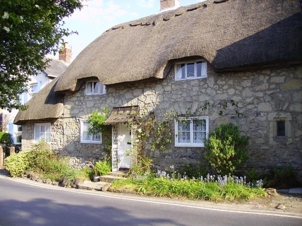 an old stone house with a thatched roof at Ye Olde Cottage in Niton