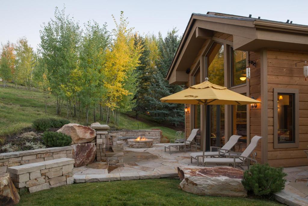 a patio with an umbrella and chairs and a fire pit at Skyline Drive - 108 in Elkhorn Village