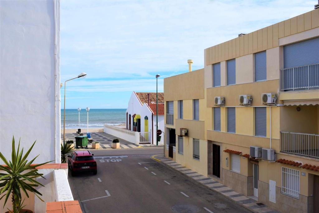 una calle frente a un edificio con la playa en Playa Pau Pi Eivissa AP945, en Oliva