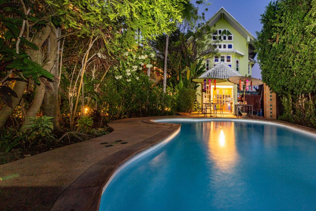 a swimming pool in front of a house at The Twenty Lodge- SHA Extra Plus in Chiang Mai