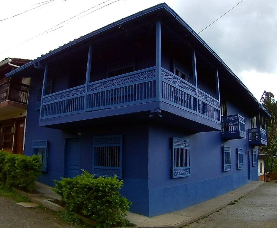 un edificio azul con un balcón en un lateral en CASA AZUL LA GARRUCHA, en Jardín