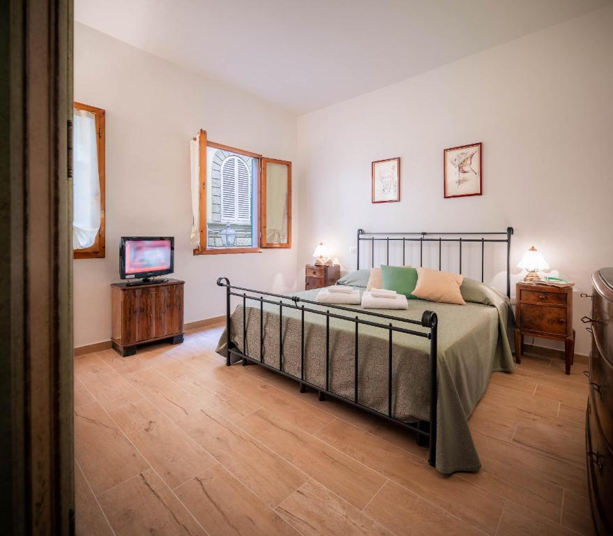 ein Schlafzimmer mit einem Bett und einem TV in der Unterkunft Novella Benedicta Apartments in Florenz
