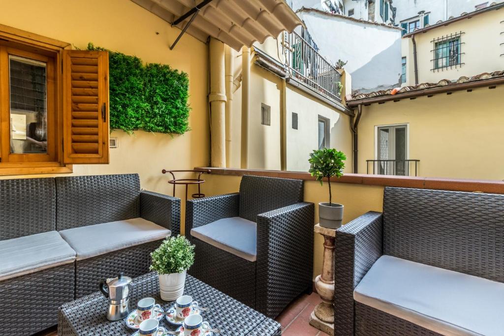 un patio con sillas y mesas en un balcón en Wine Apartments Florence Sangiovese, en Florencia