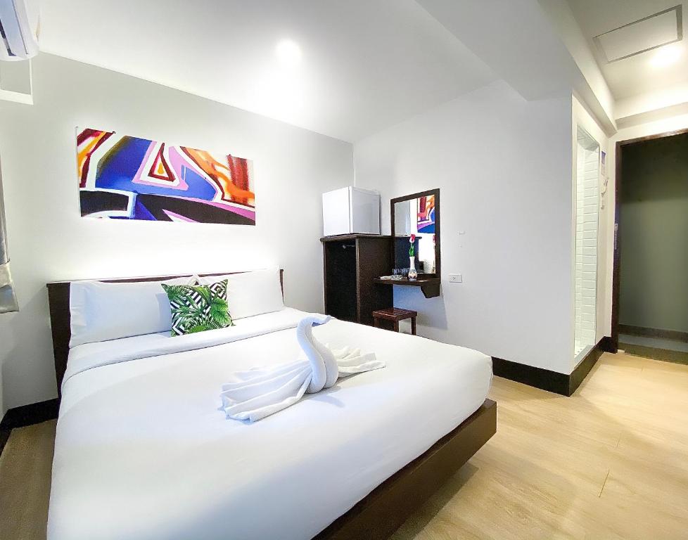 um quarto com uma grande cama branca com um cisne em New Star em Pattaya Central