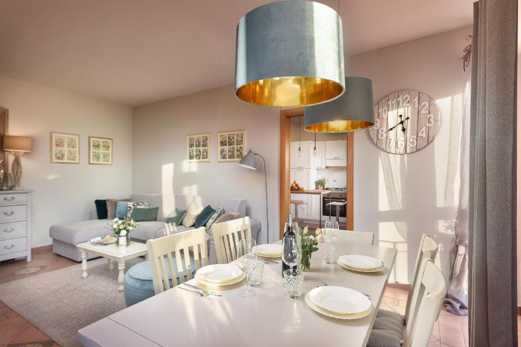 - une salle à manger et un salon avec une table et des chaises blanches dans l'établissement Villa Scarponi Assisi, à Assise