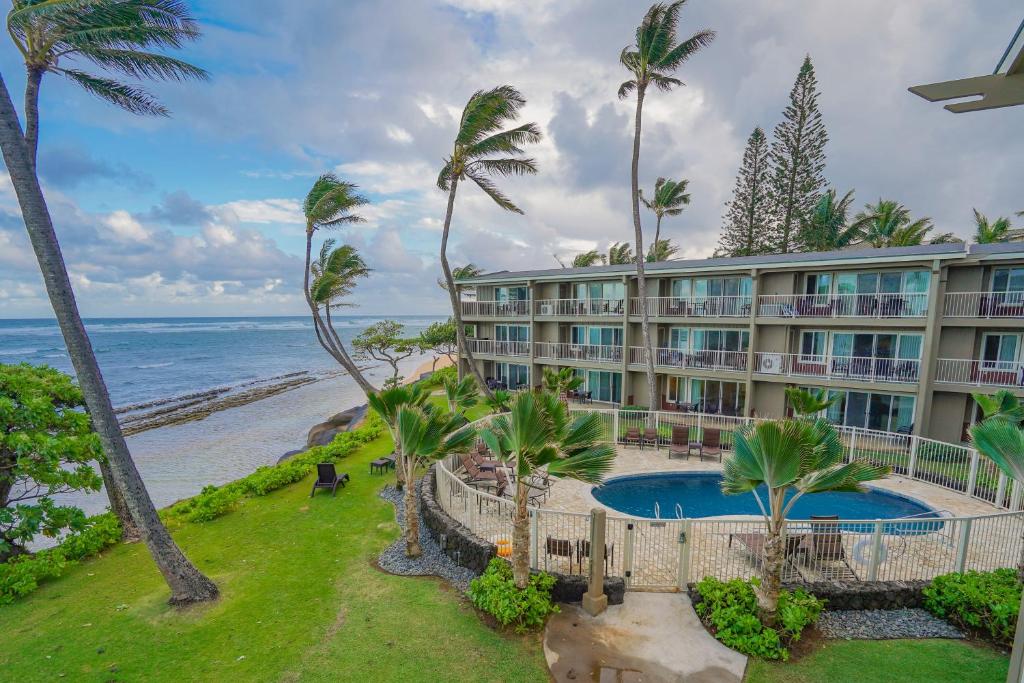 een uitzicht op een resort met een zwembad en palmbomen bij Kauai Kalani in Kapaa