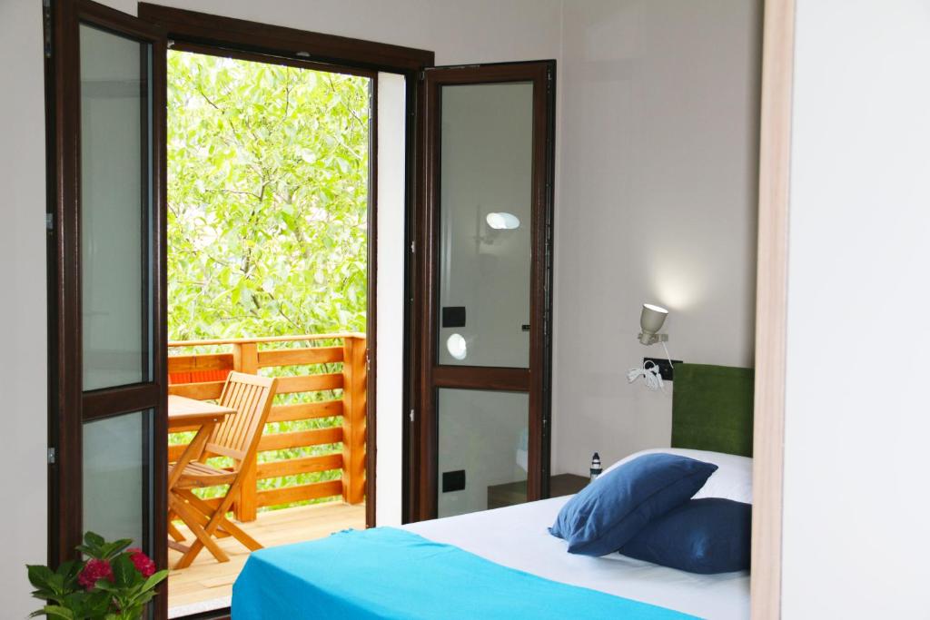 una camera con letto e un balcone con tavolo di Casa Vacanze Il Giardino - Appartamento Castagno ad Aritzo