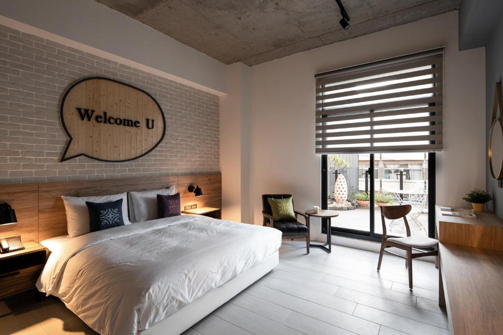 a bedroom with a white bed and a brick wall at Tian Zhong Hotel in Tianzhong