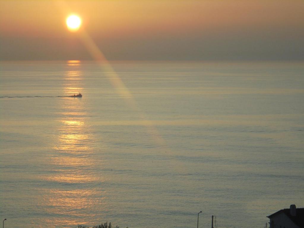 a boat in the water at sunset at Ericeira Sunset Apartment in Ericeira