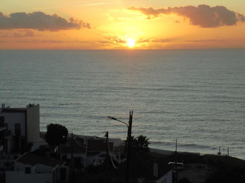 a sunset over the ocean with the sun setting at Ericeira Sunset Apartment in Ericeira