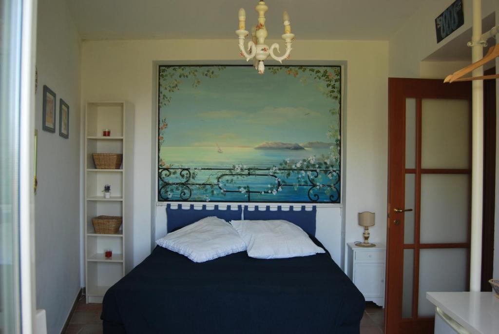 una camera con un letto blu e un dipinto sul muro di Sorrento Studios Lemons Hill a Sorrento