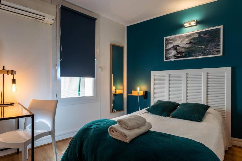 a bedroom with a bed with a blue wall at Hôtel Le Mistral in Marseille