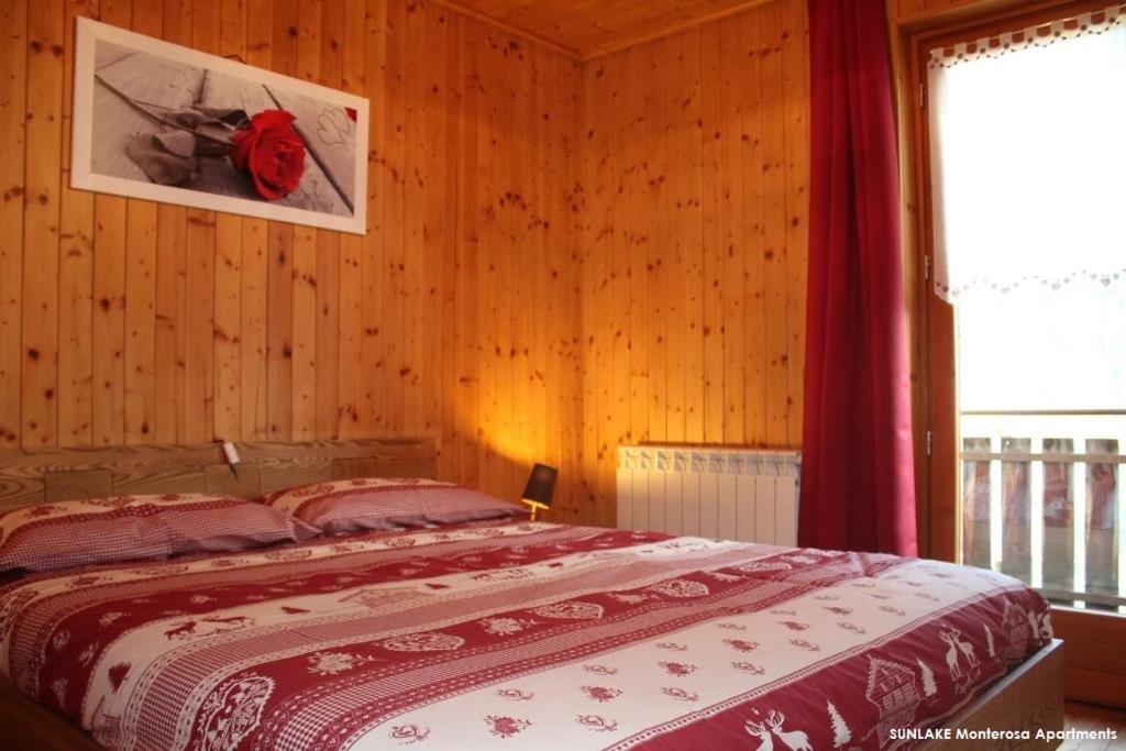 ein Schlafzimmer mit einem Bett in einer Holzwand in der Unterkunft Sunlake Magneaz in Champoluc