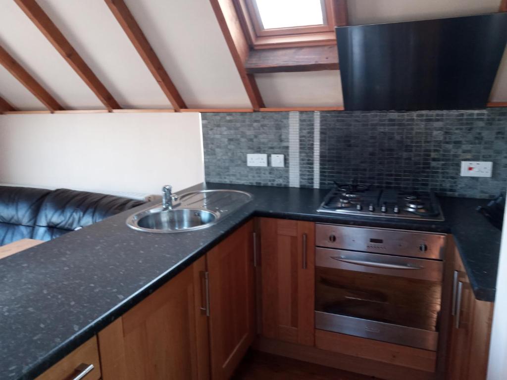 a kitchen with a sink and a stove at Rose Cottage studio in Sheffield