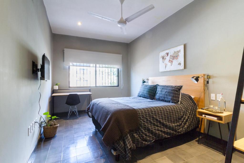 a bedroom with a bed and a desk in it at Casa Alexia in Guadalajara