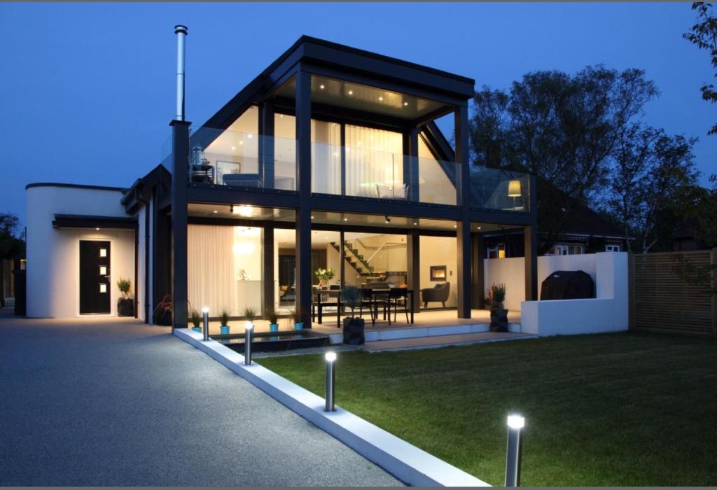 a house with a glass facade at night at Oyster Shell Whitstable in Whitstable