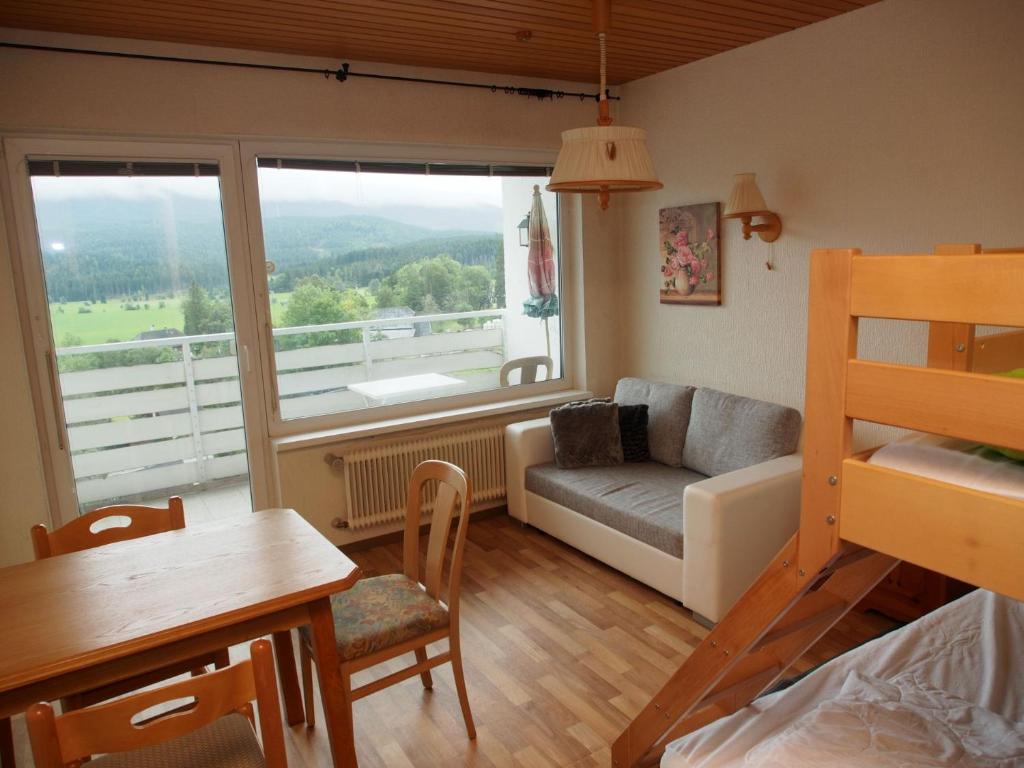 een kleine woonkamer met een bank en een tafel bij Mountain View Apartment in Bad Mitterndorf