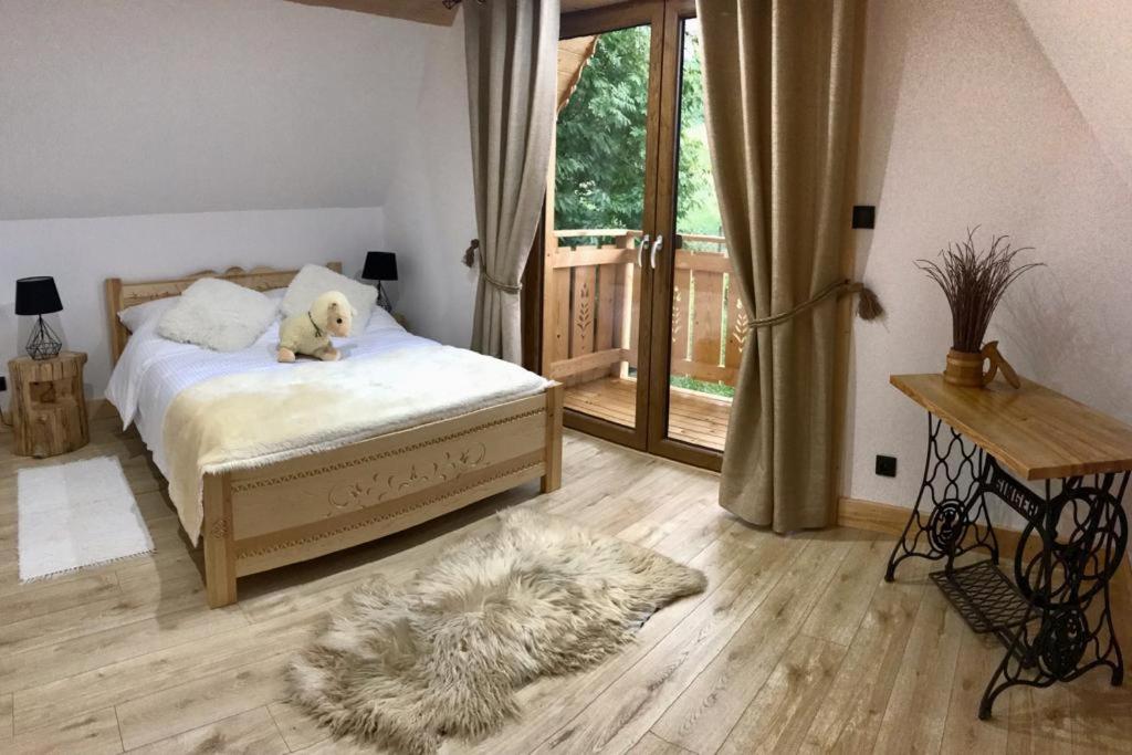 Un dormitorio con una cama con un animal de peluche encima. en Domek Góralski u Basisty, en Poronin